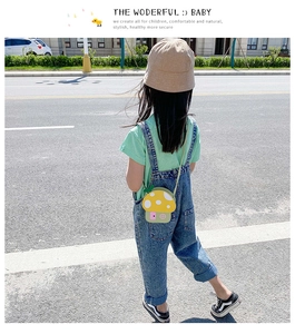 Vista posteriore di un bambino con borsa a tracolla a fungo colorata e salopette di jeans