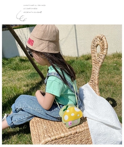Detail of cute yellow mushroom cross-body bag for girls on green grass background