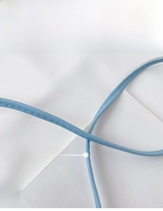 Close-up of light blue leather shoulder strap with fine stitching details
