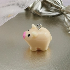 Macro shot of a cute pink resin pig pendant with a silver metal loop for DIY jewelry