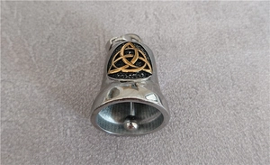 Detail view of silver Viking guardian bell pendant with golden Celtic Trinity knot