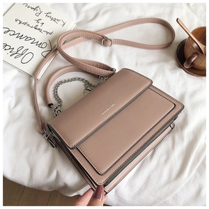 Detail of dusty pink matte PU leather crossbody bag with silver chain and brand logo