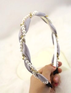 Macro view of grey silk fabric headband featuring white pearls and crystal rhinestones