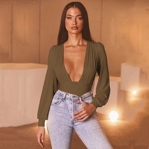 Detail of dark olive green deep V-neck long sleeve bodysuit paired with jeans