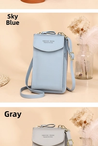 Close-up of blue and grey crossbody phone bags with Forever Young logo and soft texture