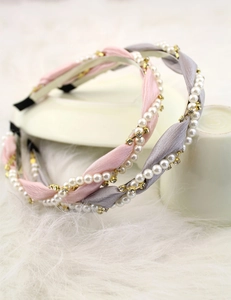 Detail of twisted satin headbands with white pearls and sparkling rhinestones