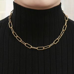 Minimalist 18K gold paperclip link chain necklace worn on a black turtleneck sweater