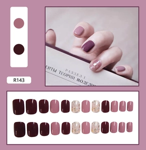 Detail view of R143 press-on nails with deep wine red and gold foil stone accents