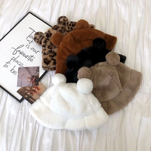 Stack of colorful leopard print faux fur bucket hats with cute bear ears on white fabric