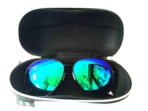 Vista macro di occhiali da sole aviator con lenti a specchio verde acqua in astuccio