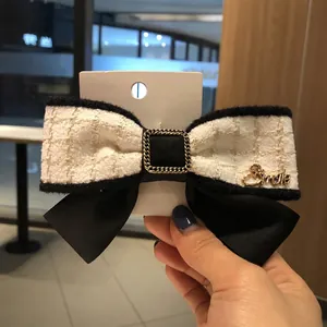 Barrette à cheveux nœud en tweed avec pendentif doré Smile et détails de chaîne