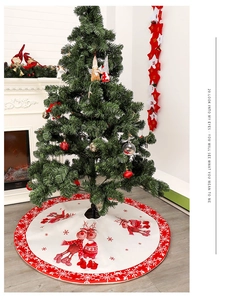 Detailed view of red and white Christmas tree skirt with reindeer and snowflake patterns