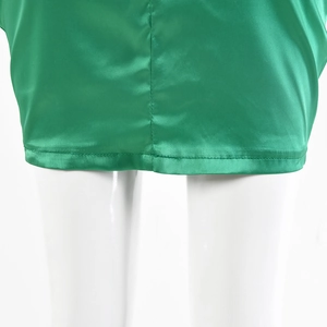 Dettaglio dell'orlo della gonna in raso verde con cuciture su manichino bianco
