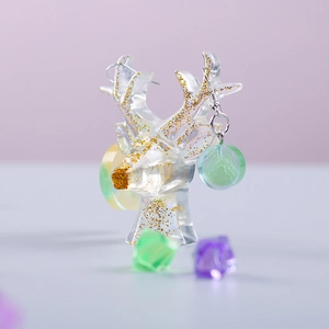 Detail of translucent resin circle earrings on a gold glitter deer head display stand