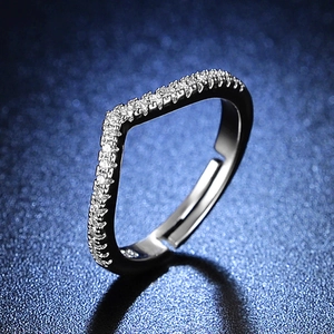 Macro shot of silver V-shaped adjustable ring with pavé diamonds on blue texture