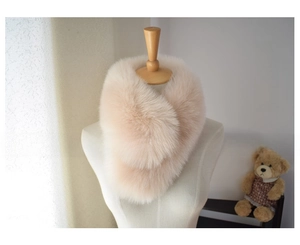 Detail view of khaki faux fox fur scarf showing plush texture and cross-clip closure