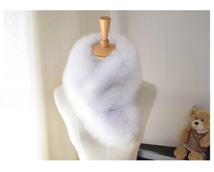 Detail of faux fox fur scarf in snow fox color with black tips on a white mannequin