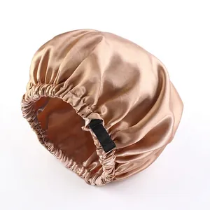 Detail of champagne satin sleep cap with adjustable black elastic buckle strap
