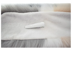 Detail of soft cotton lining and secure metal clip on a color-block faux fur scarf