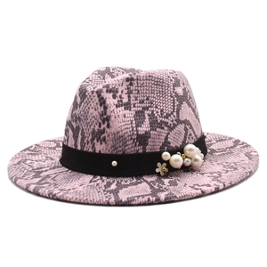 Detail of pink snake print fedora with black ribbon, white pearls and floral accent