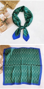 Detail of silk square scarf with green wavy pattern and blue border on woven bag
