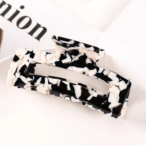 Detail of large acetate hair claw clip featuring black and white marble pattern design