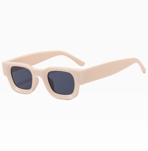 Detail view of stylish square beige sunglasses with thick frames and dark lenses