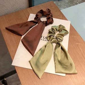 Elegant satin bow scrunchie set in dark coffee and olive green on a wooden background