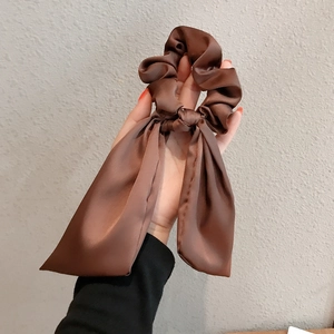Brown satin bow hair scrunchie with long ribbons for elegant ponytail styling