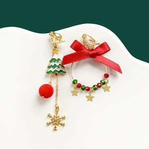 Detail of asymmetrical Christmas earrings with plush ball, bow and star charms