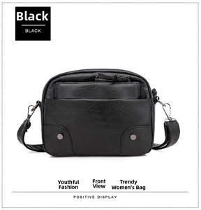 Détails avant du sac bandoulière noir avec double fermeture éclair et rivets en métal