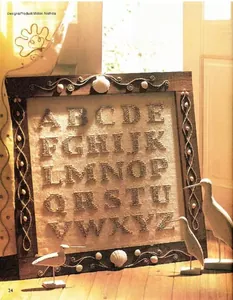 Detail von nautischer Alphabet-Stickerei im Holzrahmen mit Seil- und Muschel-Dekor