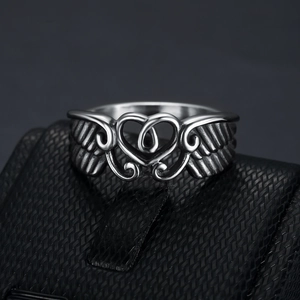Vintage style stainless steel ring with heart and wings design on a black jewelry box