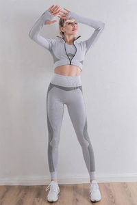 Détail d'un ensemble de yoga gris avec manches à passe-pouce et bandes noires