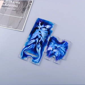 Close-up of DIY resin phone stand with blue and white fluid art texture and charging port