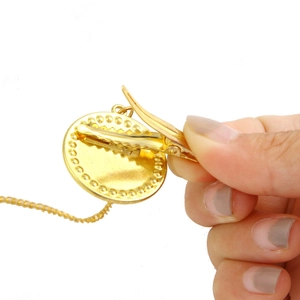 Detailed view of the gold-colored clip and chain structure of the baby pacifier accessory