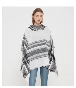 Detail shot of black and white plaid hooded poncho featuring soft tassel fringe trim