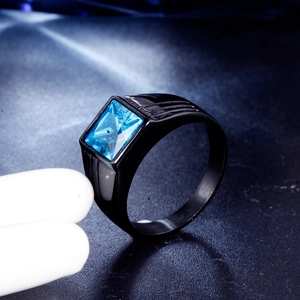 Macro shot of men's black brushed titanium ring featuring a square blue zircon stone