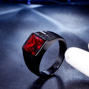 Macro shot of men's black titanium ring with a large square red gemstone and side grooves
