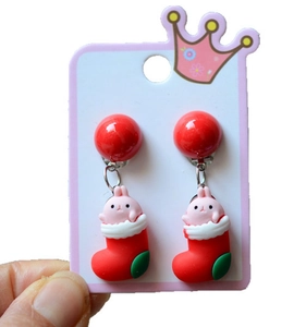 Detail view of festive resin Christmas stocking and rabbit clip-on earrings for kids