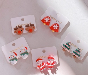 Close-up of five pairs of colorful resin Christmas earrings on a white display card