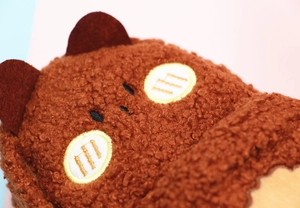 Macro shot of cute brown teddy fleece pencil case with cartoon bear ears and embroidery