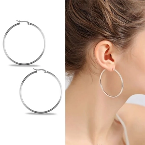 Polished silver stainless steel hoop earrings with model display for size reference
