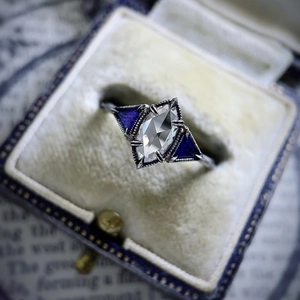 Vintage art deco ring with kite-cut zircon and blue side stones in a velvet box