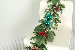 Detailed close-up of Christmas garland with pine cones, red berries and green ornaments