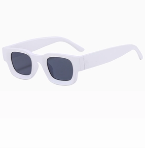 Close-up of stylish white thick-frame sunglasses with square dark lenses and a glossy finish