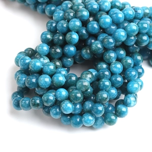 Strand of natural blue apatite round stone beads for DIY jewelry making on white background