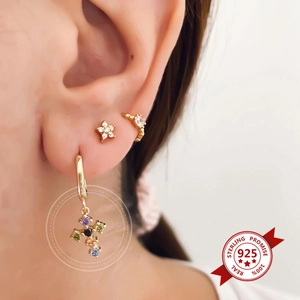 Detail of S925 silver gold-plated earrings set with cross pendant and crystal star stud