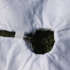 Detail of white faux fur Christmas tree skirt showing the velcro closure and round opening