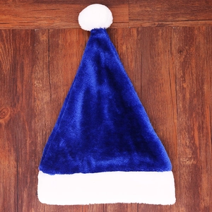 Close-up of blue plush Christmas hat with white faux fur trim on wooden background